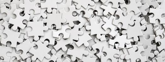 Close-up of a pile of uncompleted elements of a white puzzle. A huge number of rectangular pieces from one large white mosaic photo