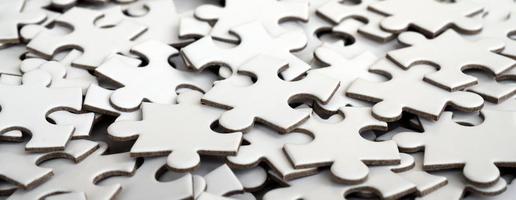 Close-up of a pile of uncompleted elements of a white puzzle. A huge number of rectangular pieces from one large white mosaic photo