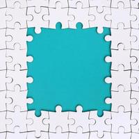 Framing in the form of a rectangle, made of a white jigsaw puzzle around the blue space photo