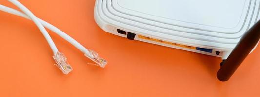 Internet router and Internet cable plugs lie on a bright orange background. Items required for Internet connection photo