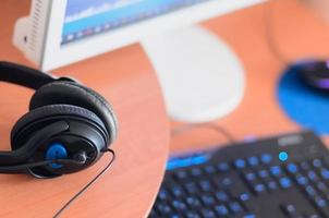 Big black headphones lie on the wooden desktop of the sound designer photo