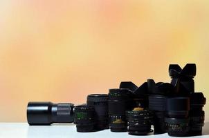 muchas lentes profesionales diferentes para cámara slr se encuentran en un escritorio incoloro foto