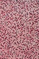 The texture of the wall, decorated with a mosaic of various small square tiles. Abstract pattern of ceramic tiles on the wall photo