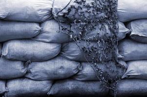 Background of many dirty sand bags for flood defense. Protective sandbag barricade for military use. Handsome tactical bunker photo