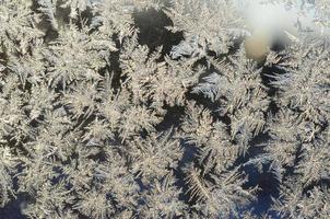 Snowflakes frost rime macro on window glass pane photo