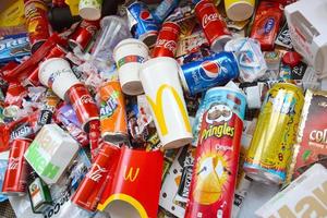 KHARKOV, UKRAINE - JULY 2, 2021 Many wrappings and cans from used products by famous worldwide brands. Pattern of trash of various colors and materials photo