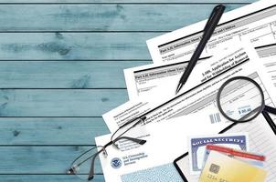 USCIS form I-589 Application of asylum and for withholding of removal lies on flat lay office table and ready to fill. U.S. Citizenship and Immigration services paperwork concept photo