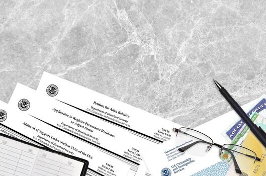 I-130 Petition for alien relative, I-485 Application to register permanent residence or adjust status and I-864 Affidavit of support under section 213A of the INA forms lies on table photo