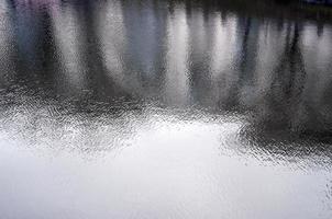 The texture of the water in the river under the influence of wind. A lot of shallow waves on the water surface photo