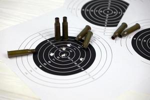 Many bullets on shooting targets on white table in shooting range polygon. Training for aiming and shooting photo