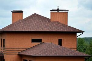 The house is equipped with high-quality roofing of shingles bitumen tiles. A good example of perfect roofing. The roof is reliably protected from adverse weather conditions photo