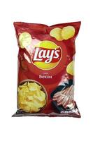 KHARKOV, UKRAINE - JANUARY 3, 2021 Lays potato chips with bacon flavour and original lays logo in middle of package. Worldwide famous brand of potato chips photo