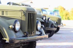 Photo of the cabins of three military off-road vehicles from the times of the Soviet Union. Side view of military cars from the front wheel