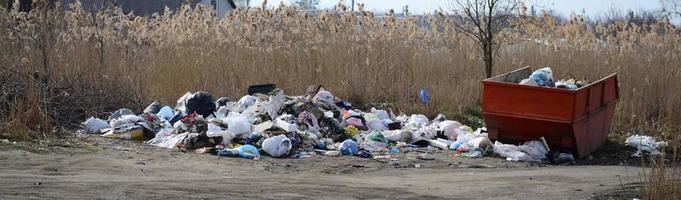 el bote de basura está lleno de basura y desechos. retiro intempestivo de basura en zonas pobladas foto