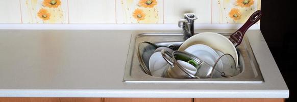 platos sucios y electrodomésticos de cocina sin lavar llenaron el fregadero de la cocina foto
