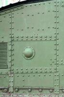 Texture of tank side wall, made of metal and reinforced with a multitude of bolts and rivets photo