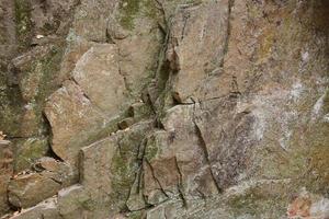 Light coarse natural rock stone background. Mining cliff rough front surface. Big limestone stack backdrop. Heavy grunge damaged granite block texture photo