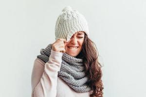 Laughing girl vistiendo ropa de abrigo gorro y bufanda aislado sobre fondo blanco. foto