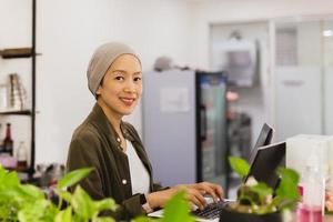 Confident restaurant owner business woman standing behind the counter and using laptop while working. photo