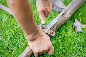 Elderly man twists the nut by wrench photo