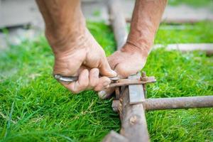 Elderly man twists the nut by wrench photo