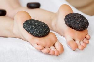 Hot stones lying on female feet photo