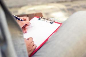 Female hand writing on a blank planner photo