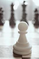 Single pawn against many enemies as a symbol of difficult unequal fight or struggle of minorities. Background in blur. photo