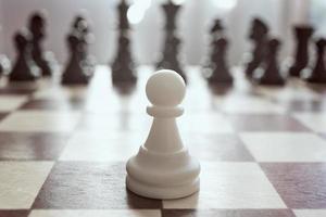 Single pawn against many enemies as a symbol of difficult unequal fight or struggle of minorities. Background in blur. photo