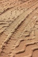 Huellas de neumáticos en arena en tono marrón. fondo abstracto y patrón. foto