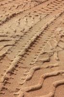 Tyre tracks on sand in brown tone. Abstract background and pattern. photo