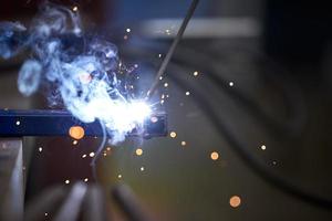 The connection of two parts by welding close-up. Welding work. Sparks fly in different directions. photo
