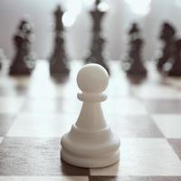 Single pawn against many enemies as a symbol of difficult unequal fight or struggle of minorities. Background in blur. photo
