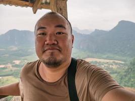 Portrail photo of Fat tourist with beautiful view on the peak of Pha Ngeun in vangvieng City Laos.Vangvieng City The famous holiday destination town in Lao.