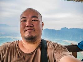 foto de retrato de turista gordo con hermosa vista en el pico de pha ngeun en la ciudad de vangvieng laos. ciudad de vangvieng la famosa ciudad de destino de vacaciones en lao.