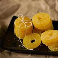 Lemon, orange and grapefruit slices in sugar isolated on a wooden background, close-up. Marmalade sweets. Sweets with citrus flavor. Candies photo