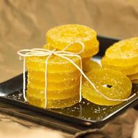 Lemon, orange and grapefruit slices in sugar isolated on a wooden background, close-up. Marmalade sweets. Sweets with citrus flavor. Candies photo