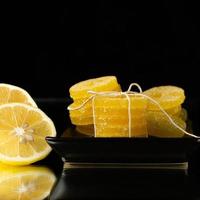 Lemon, orange and grapefruit slices in sugar isolated on a wooden background, close-up. Marmalade sweets. Sweets with citrus flavor. Candies photo