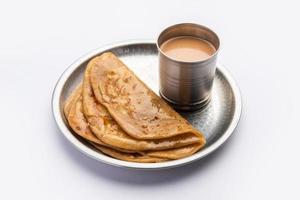 chai paratha: el té caliente servido con pan plano es una comida tradicional sencilla de india y pakistán foto