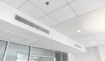 Ceiling mounted cassette type air conditioner and modern lamp light on white ceiling. duct air conditioner for home or office photo