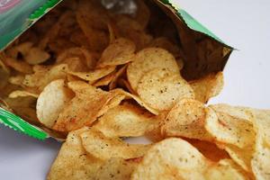 Potato chips in open bag, delicious BBQ seasoning spicy for crips, thin slice deep fried snack fast food in open bag. photo