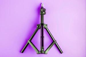 Tripod on pink background for photo-video camera and flash. Free space photo