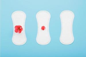 Women's Sanitary pads on a blue background. The concept of critical days, menstrual cycles in several stages. photo