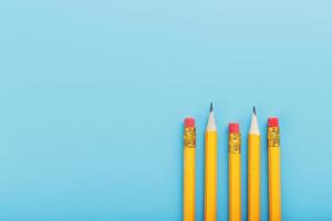 Orange pencils with an eraser on a blue background. photo