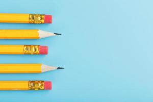 Orange pencils with an eraser on a blue background.