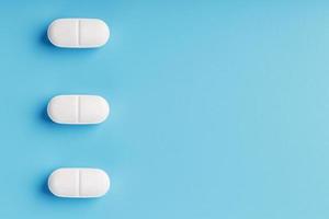 Three medicinal tablets in a row on a blue background, isolate. photo