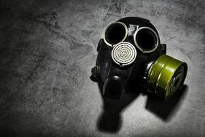 Gas mask on a black stone background, protection from dangerous infection. photo