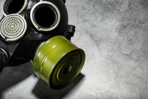 Gas mask on a black stone background, protection from dangerous infection. photo