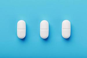 Medicinal tablets in a row on a blue background, isolate. photo