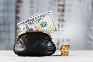 Wallet with gold coins and dollars on a gray background. Budget for investment in the future. photo